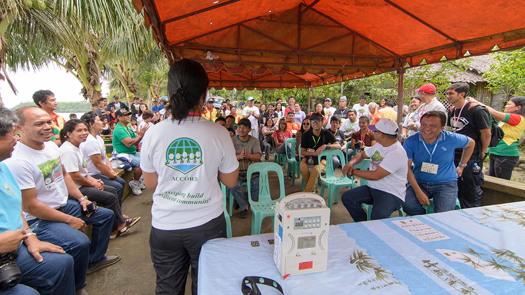Participants of "Ugnayan at Bahaginan" conference discuss their experiences and ideas on small-scale mitigation during their visit to a mangrove reforestation project in Barangay Cagsao in Calabanga, Camarines Sur. (Jigs Tenorio / ACCORD)